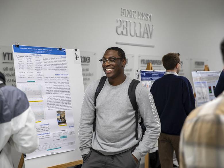 Student presents research poster in Beaver building